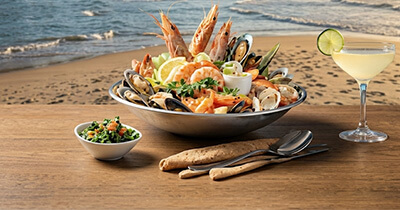 Plato gourmet y cocteleria frente al mar